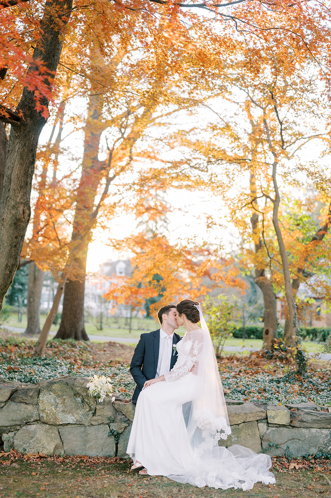 couple kissing on front lawn glenn foerd with fall leaves sunset
