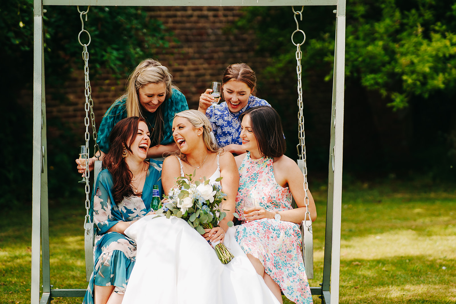 bride and friends on a swing at hornington manor wedding venue