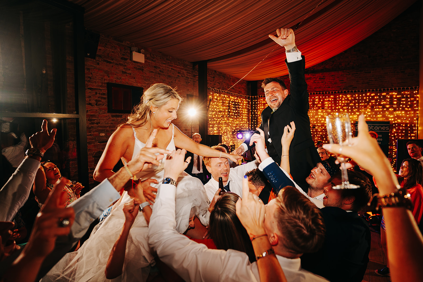 bride and groom lifted into the air on dancefloor at hornington manor