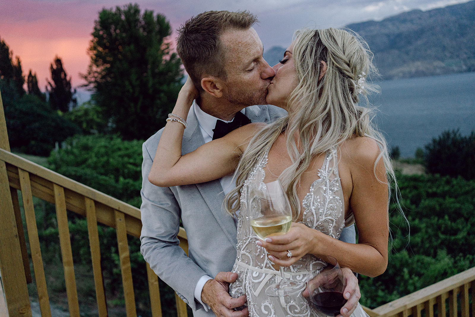 Bride and groom kiss on the patio overlooking their Oak Estate Winery wedding.