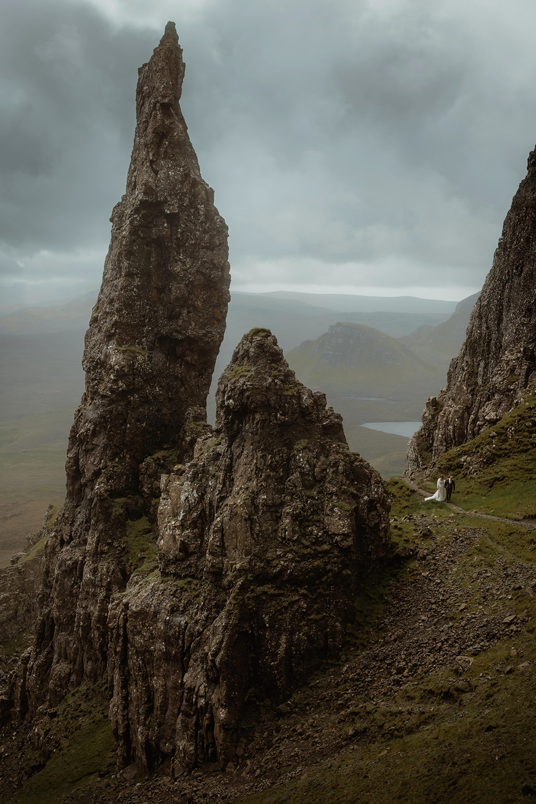 Elopement couple Emma and Matthew walking hand in hand along the path next to the Needle at the Quiraing, Isle of Skye