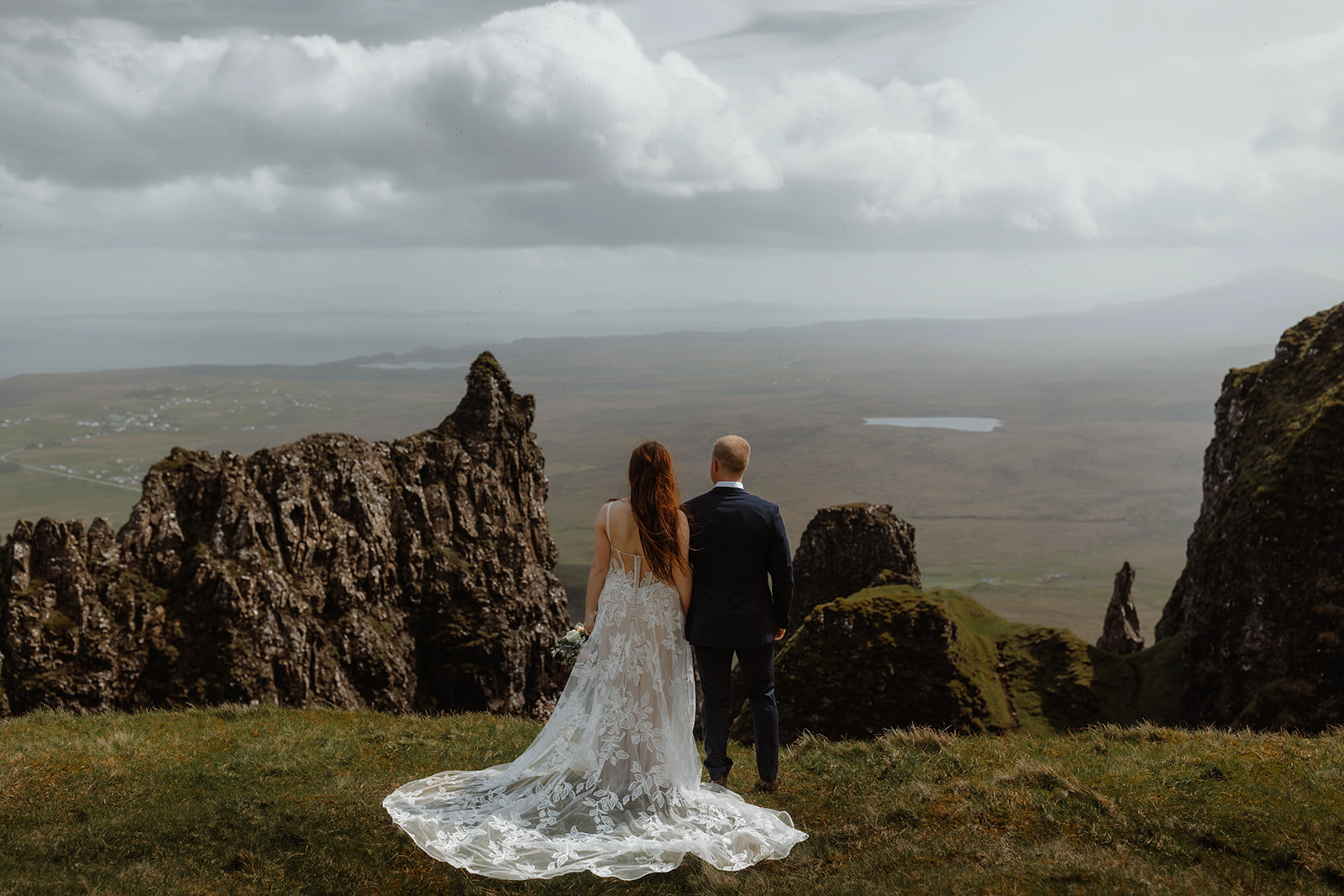 Emma and Matthew stand hand in hand as they admire the picturesque beauty of the Isle of Skye during their elopement day