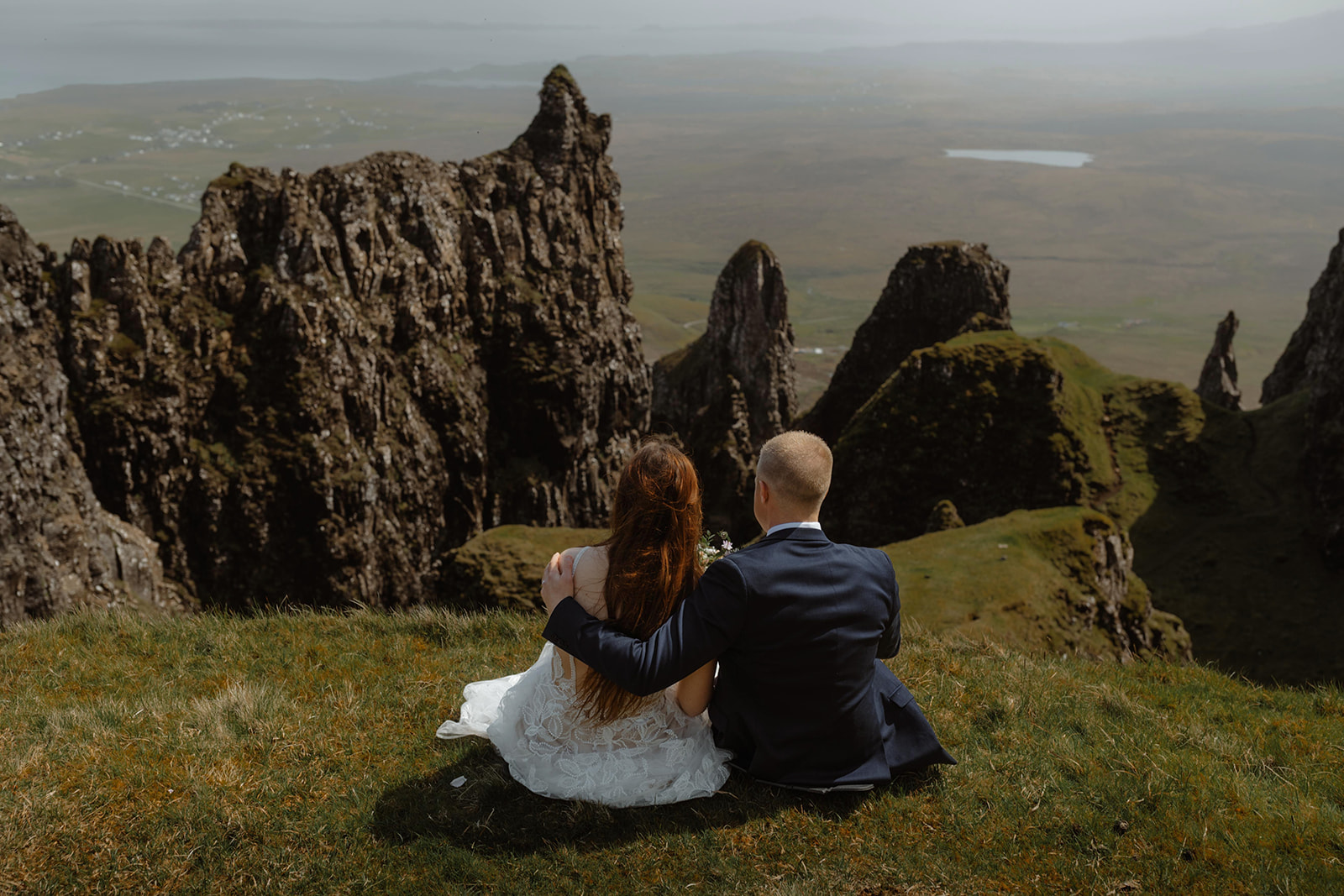 Emma and Matthew sat atop of a hill as they admire the picturesque beauty of the Isle of Skye during their elopement day