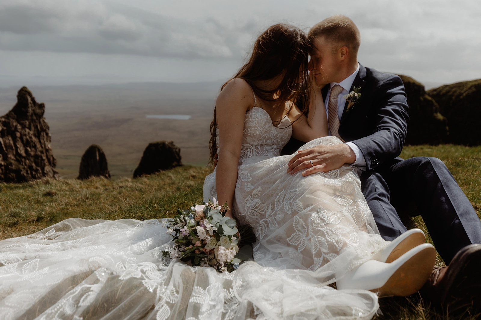 Emma and Matthew sat atop of a hill as they admire the picturesque beauty of the Isle of Skye during their elopement day