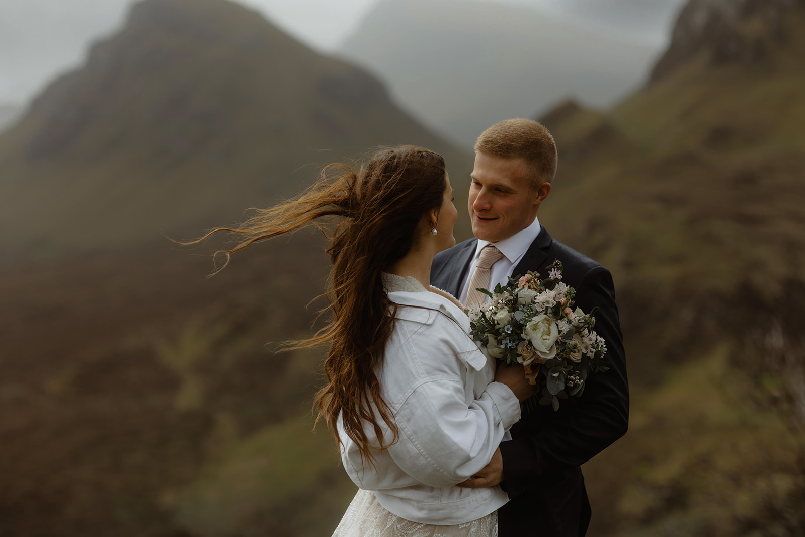 Elopement couples, Emma and Matthew embrace on top of Quiraing, Isle of Skye