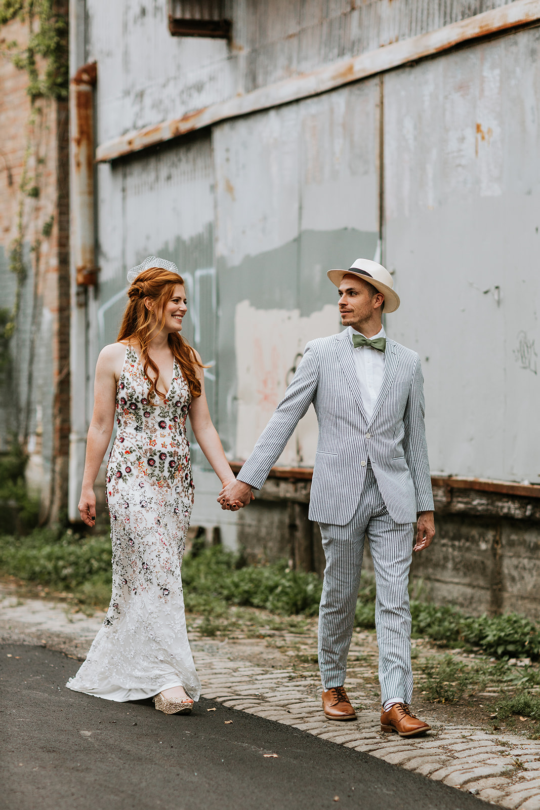 Bride and Groom walking hand and hand in floral print and a seersucker suit, a spring wedding in New Orleans