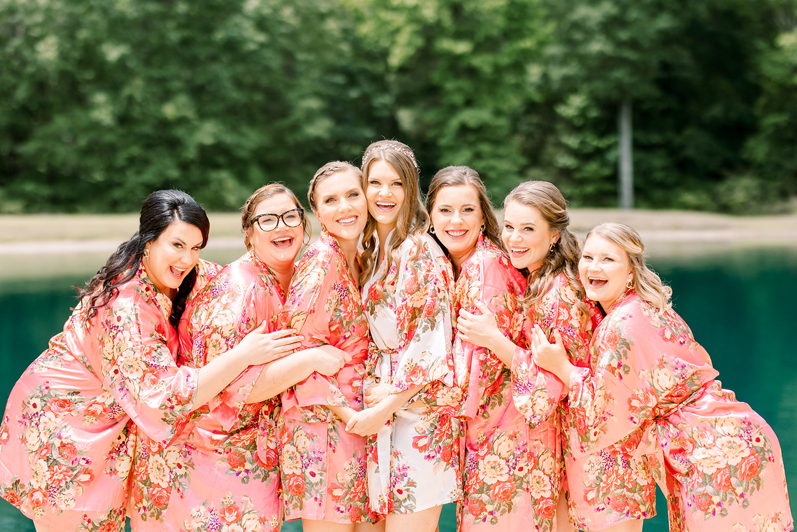 Bride and bridesmaids hugging in getting ready robes attire