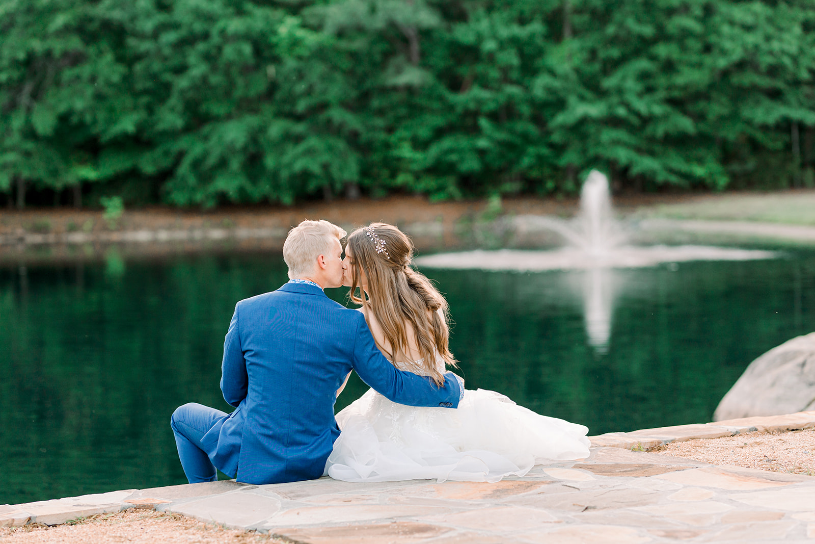 Couple sitting by pond on wedding day at Walnut Hill