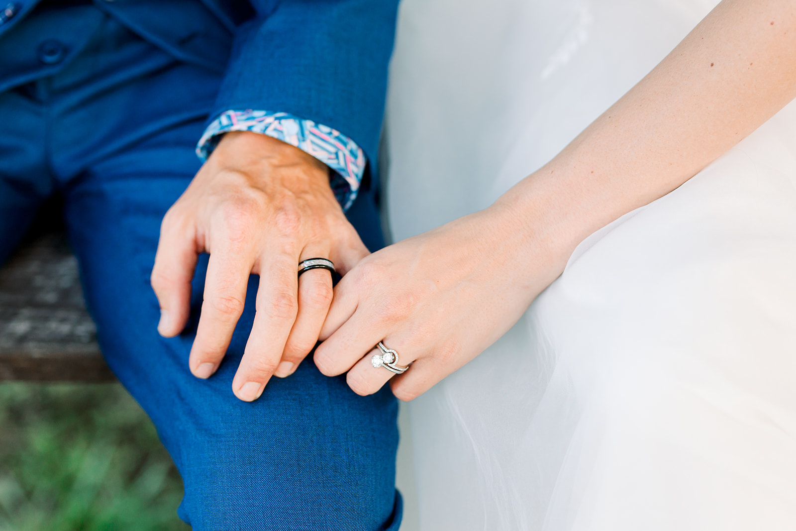 Wedding rings with couple holding hands