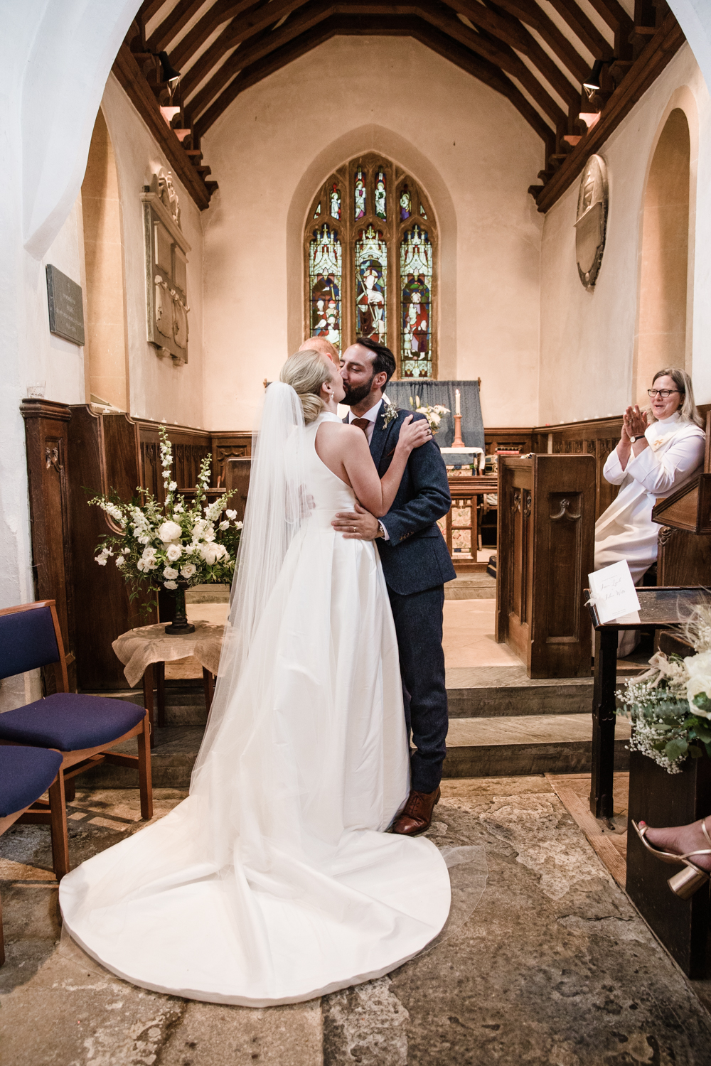 A newly married couple kiss following a church wedding ceremony