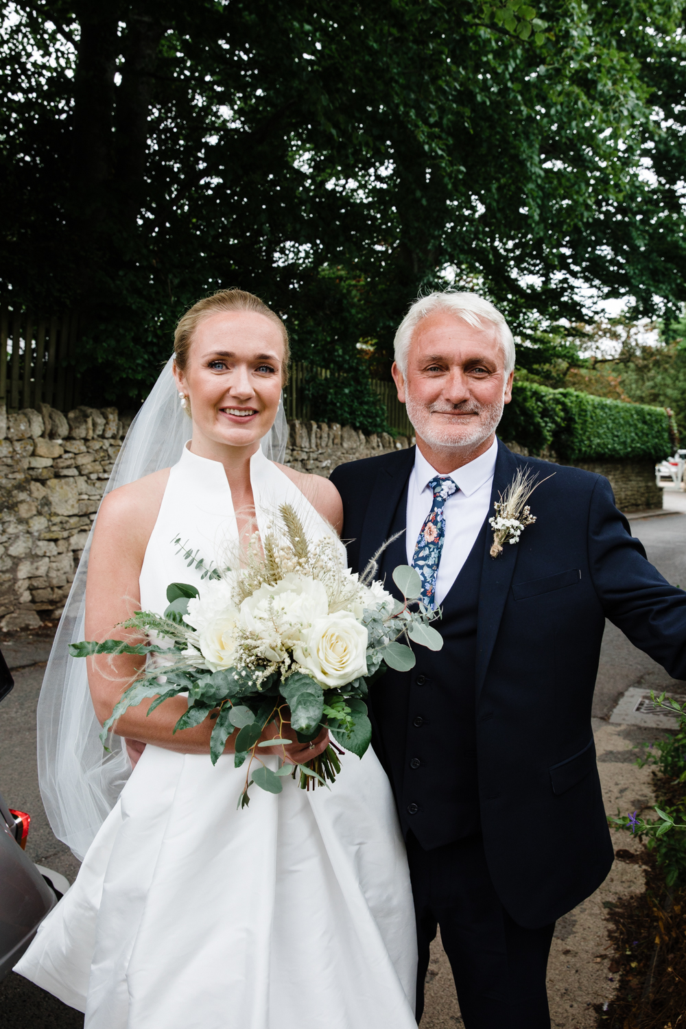 A bride and her father pose for a photograph before walking down the aisle