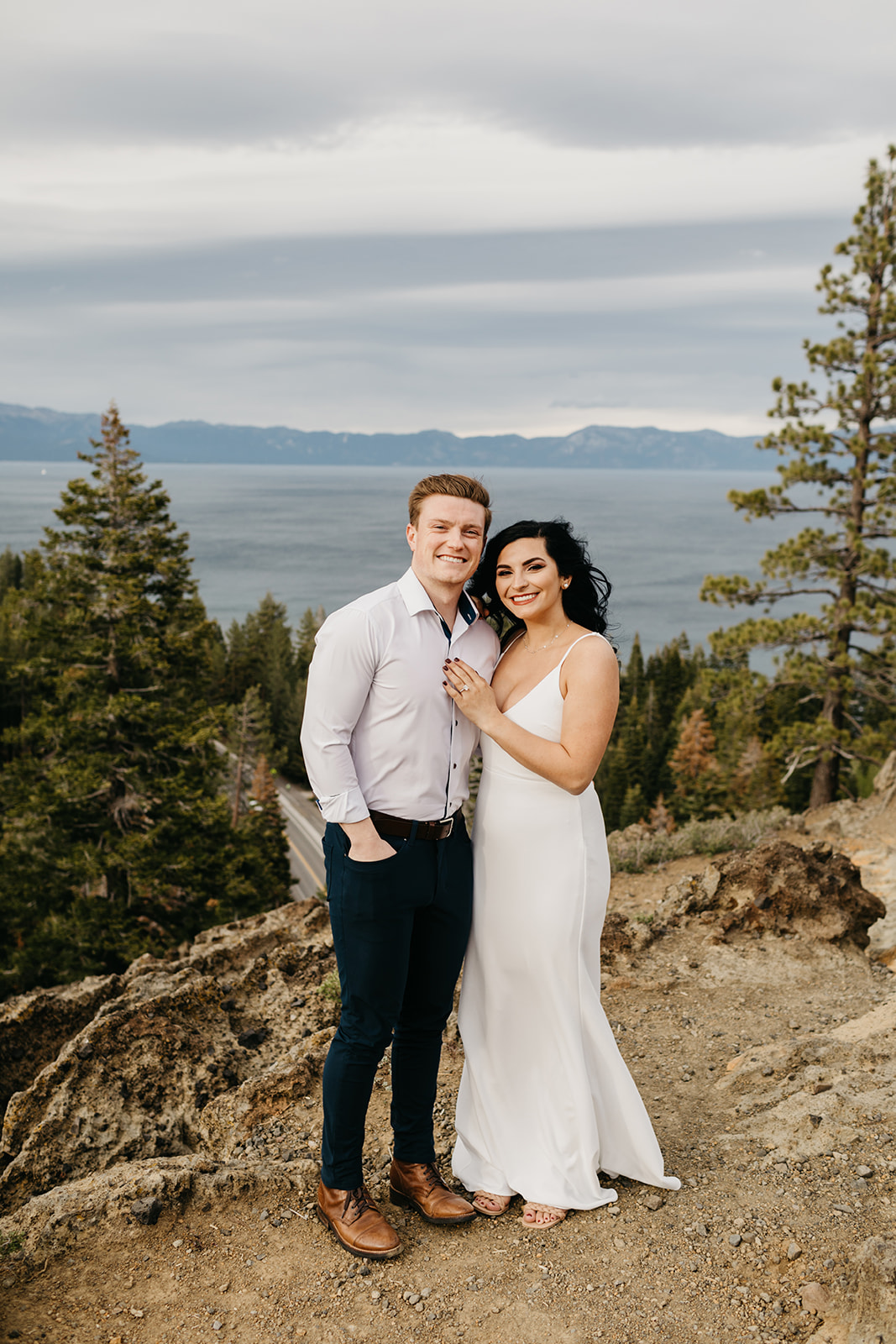 Couple poses, smiling at the camera in lake tahoe