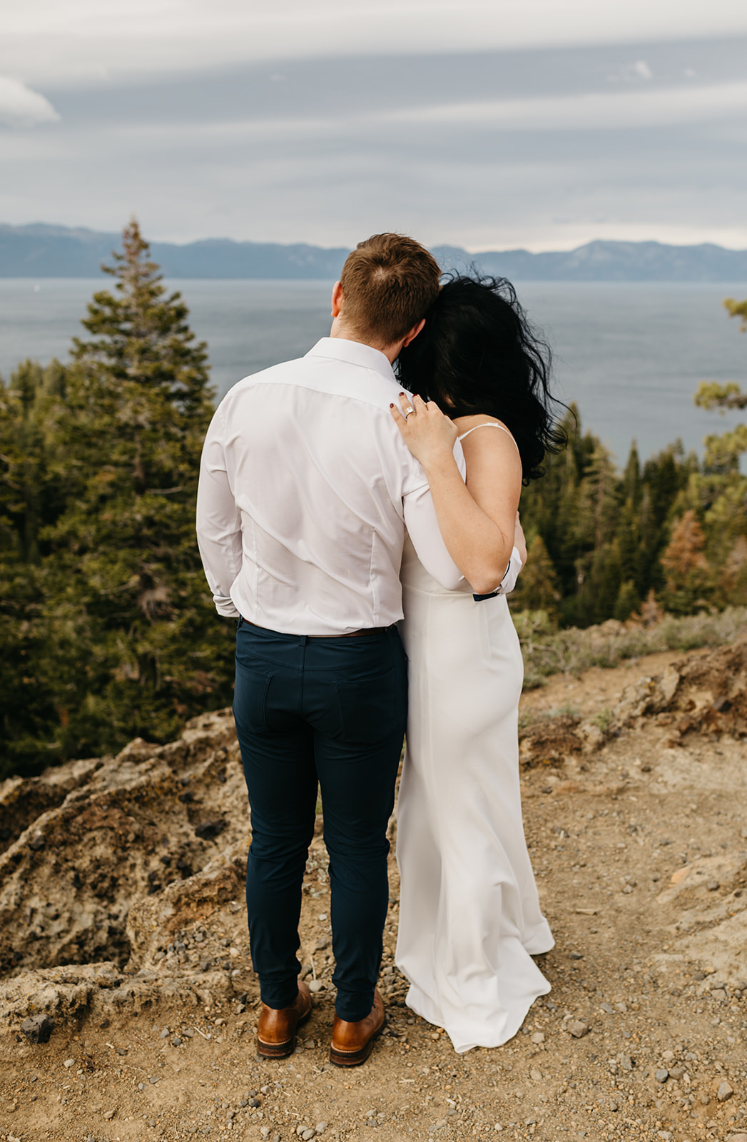 Couple wrapped up together with their backs to the camera looking out upon north lake tahoe