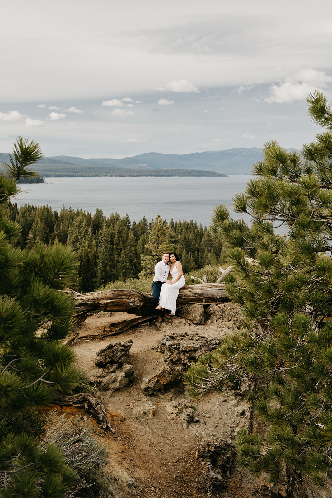 A couple sitting on a fallen tree in North Lake Tahoe