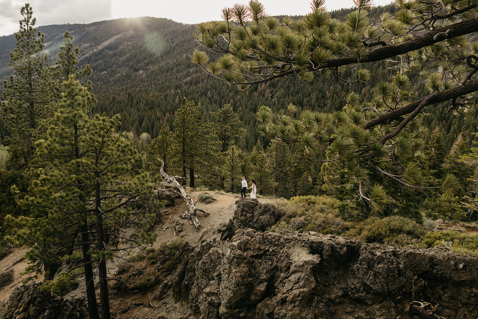 A newly engaged couple walks through tahoe national forest