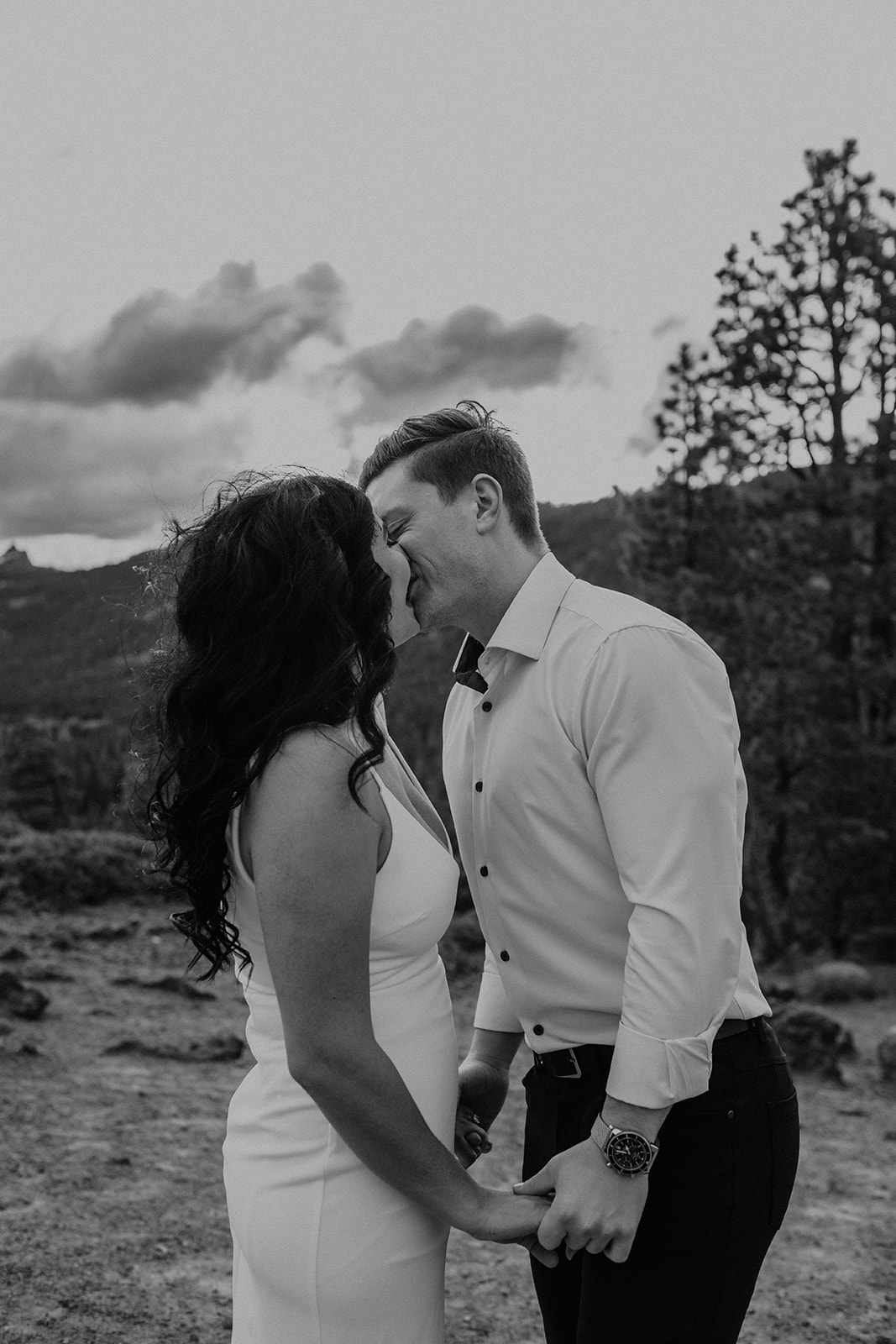 A black and white photo of a couple kissing 