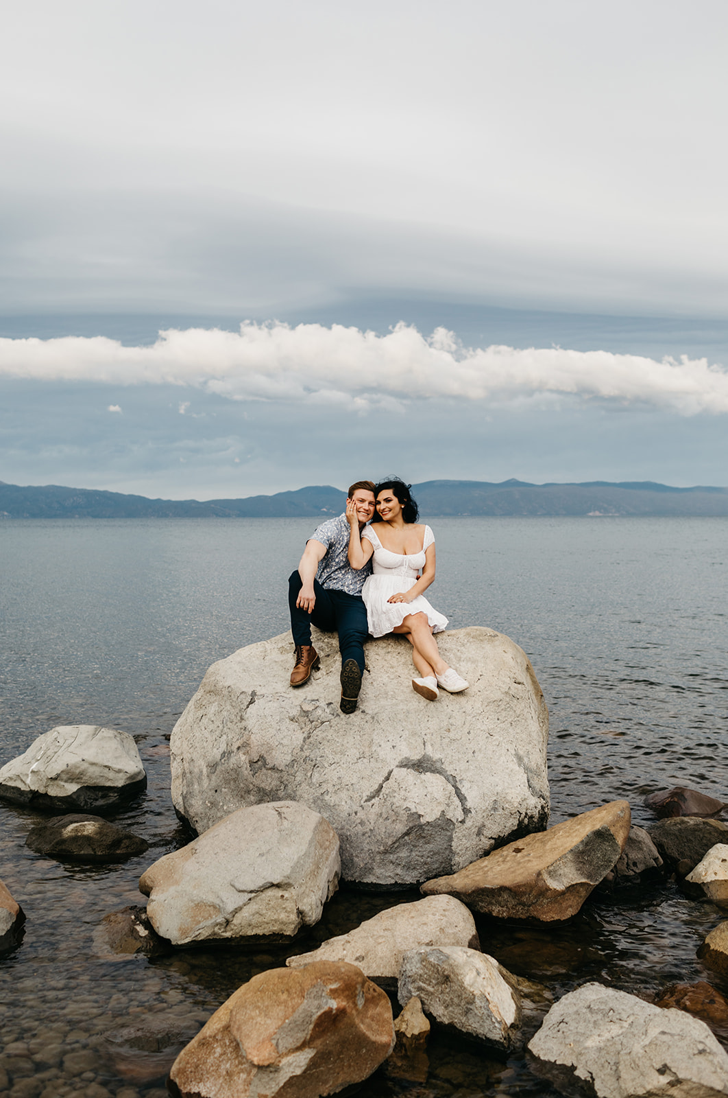 A couple sitting on a boulder on west lake tahoe