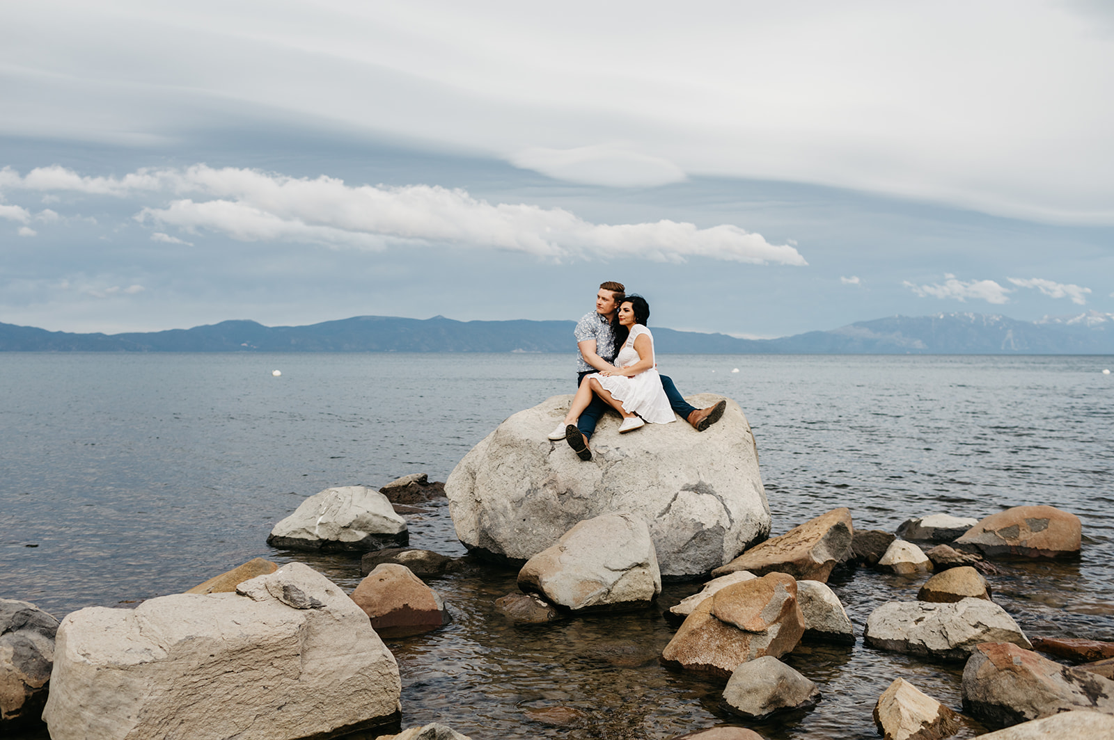 A couple sitting on a boulder on west lake tahoe