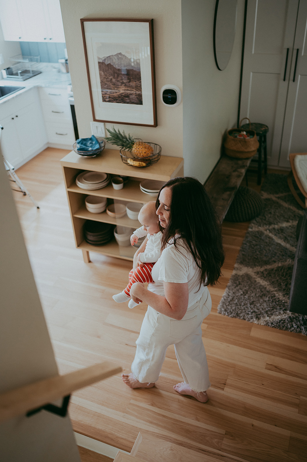 Mother walking in designer home with baby