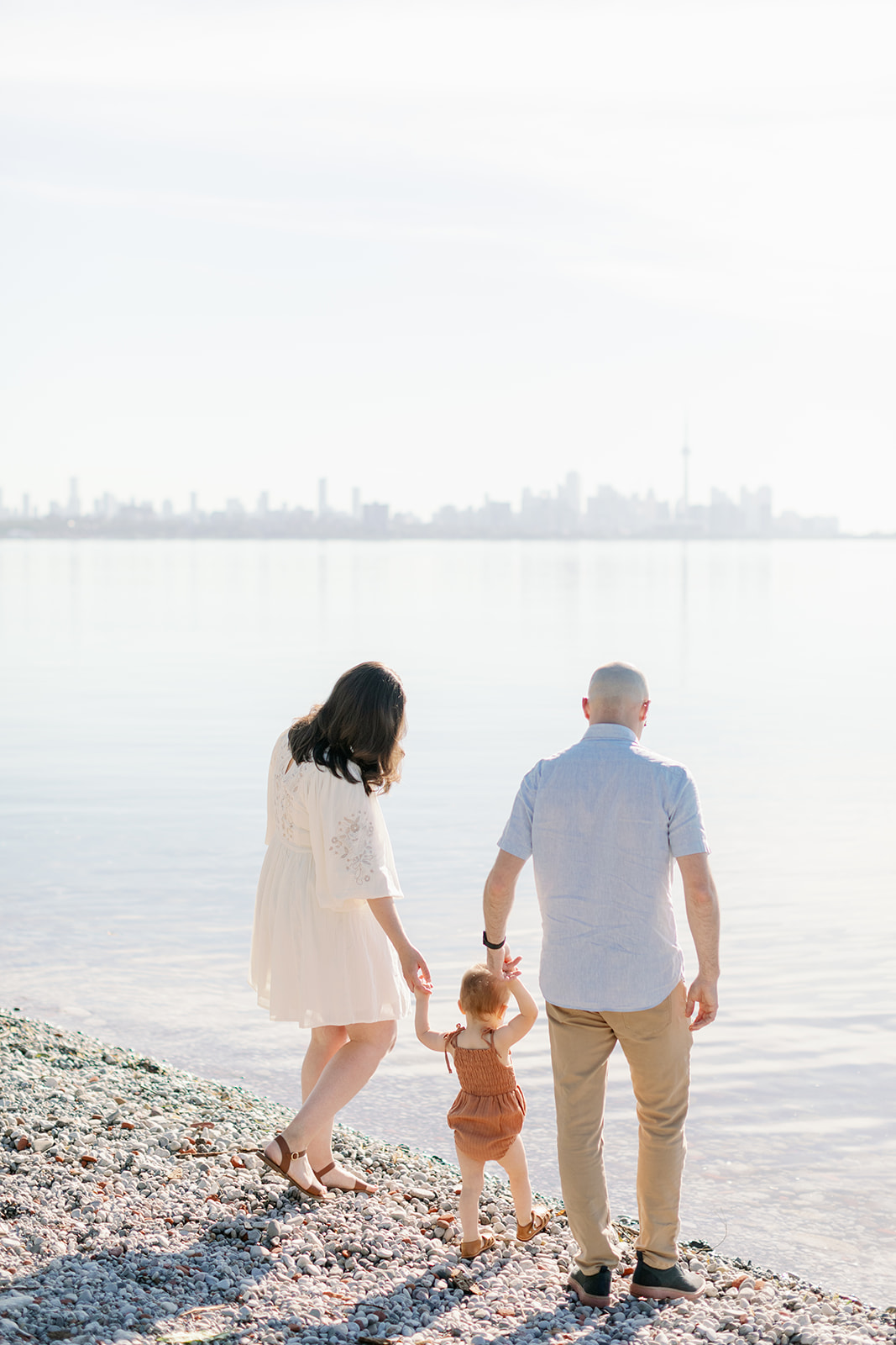 Family holds hands on the beach during family photoshoot on the Toronto Islands