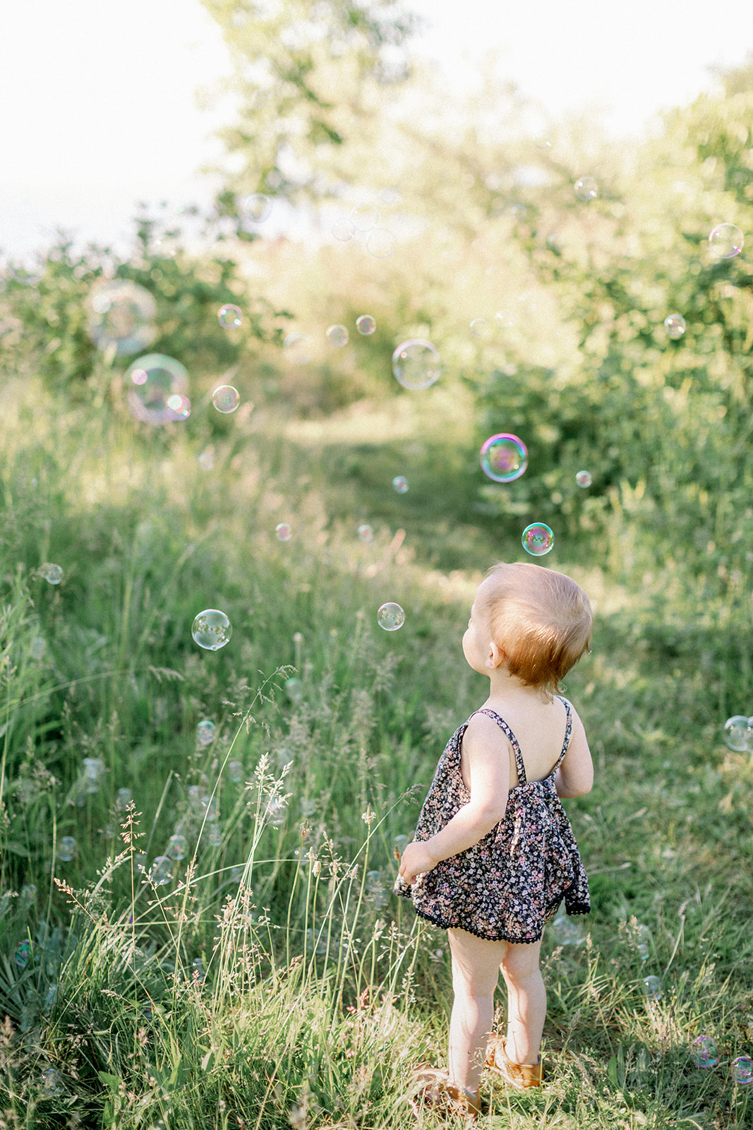 Little girl plays amongst bubbles in a moment of wonder on the Toronto Islands