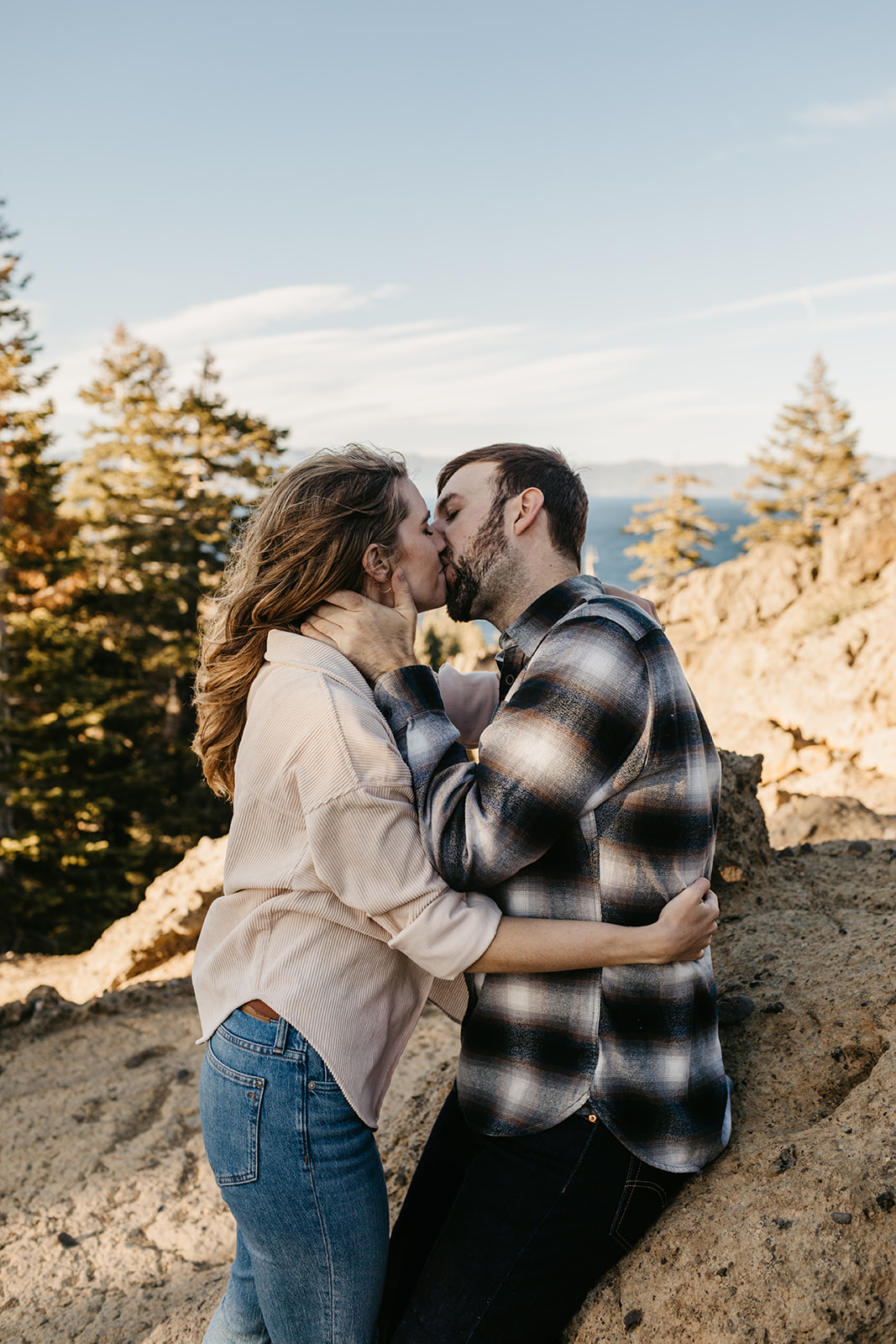 A couple kisses on top of a mountain in Lake Tahoe California