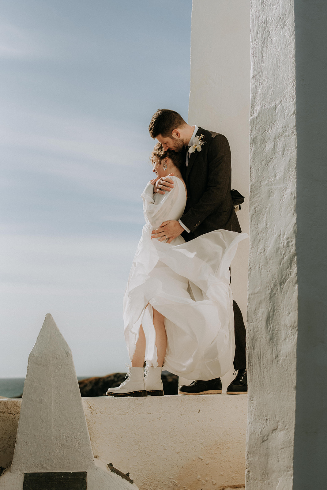A couple who eloped at Sheringham Point Lighthouse near Shirley BC take portraits in the wind