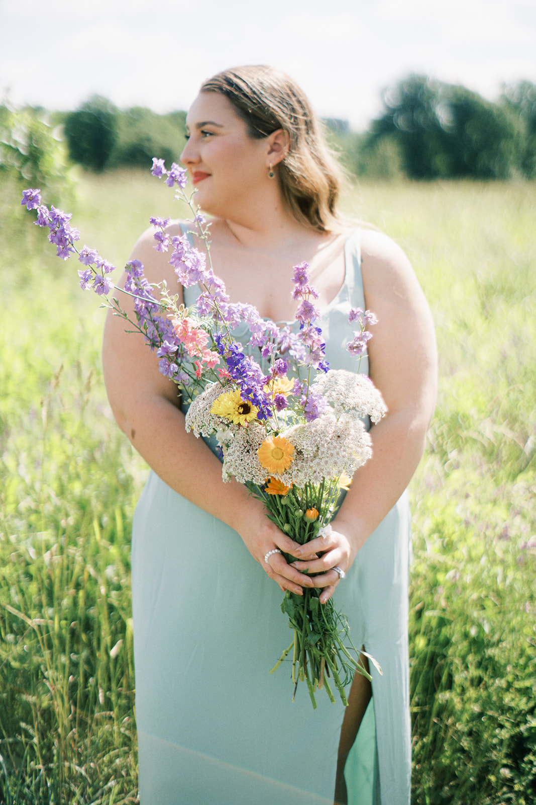 She holds a bouquet of organic flowers in the field at Wolf Thicket Farm in Fyffe, Alabama