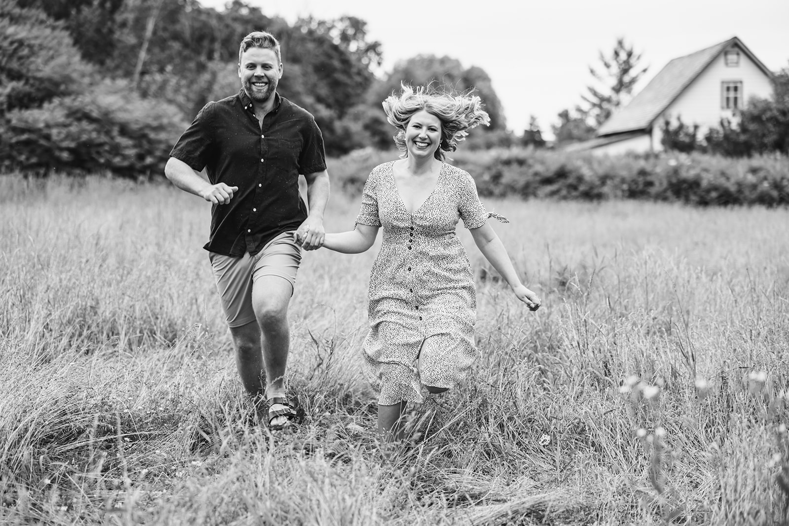 Candid engagement photos in a picturesque field setting