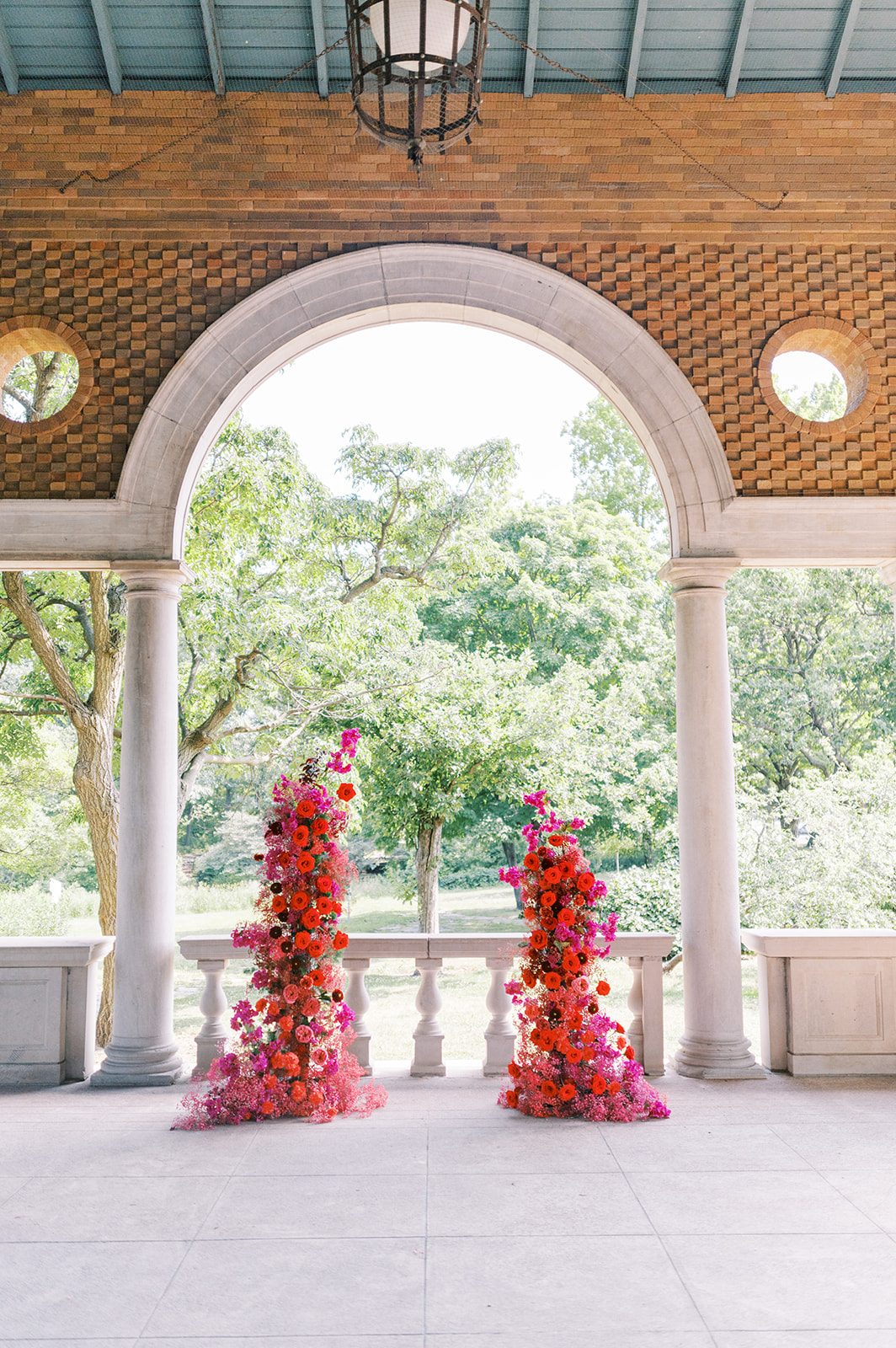 modern bright red and fuchsia floral wedding arch at columbus park refectory
