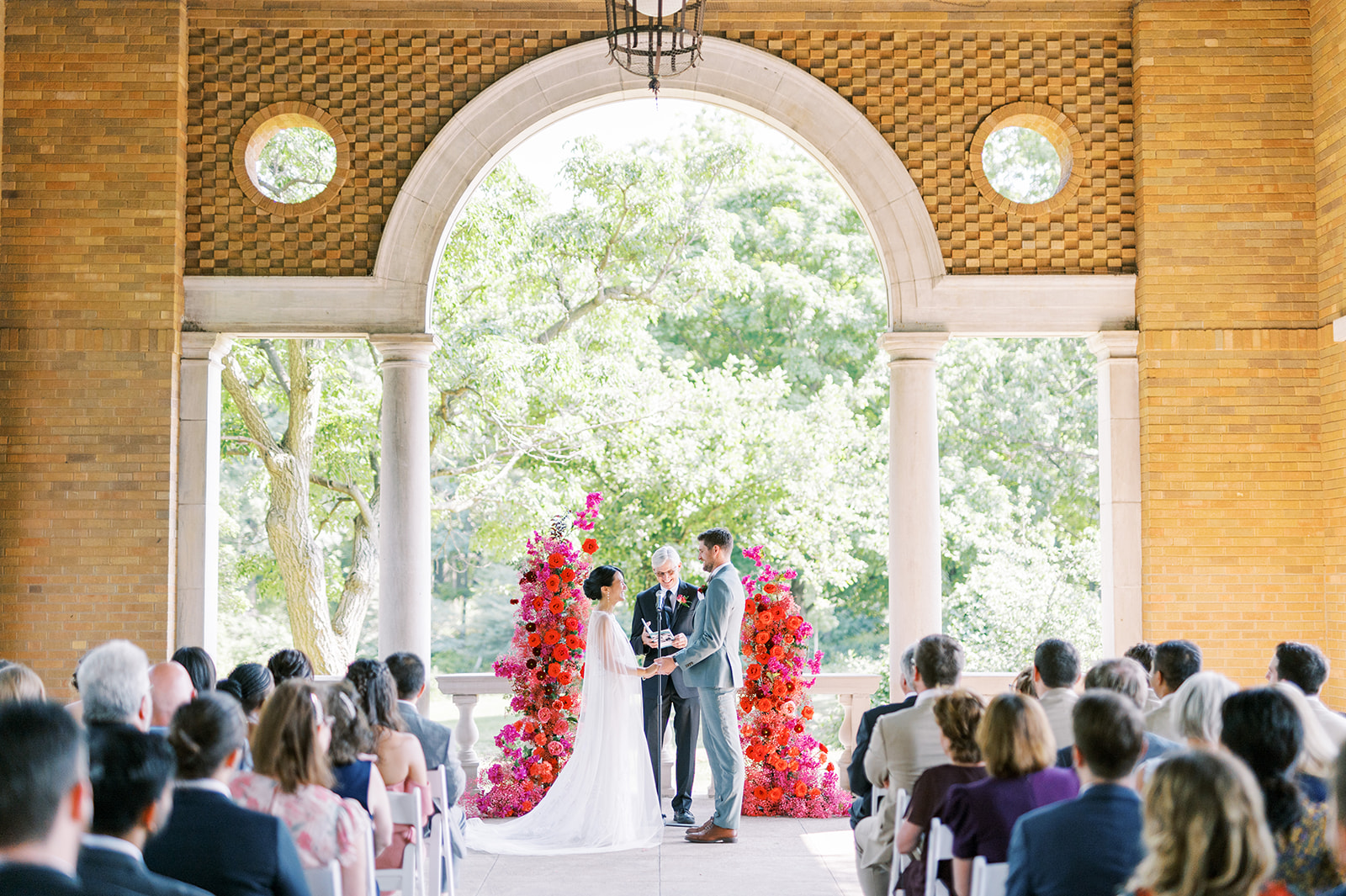 modern columbus park refectory wedding ceremony with bright red and fuchsia floral arch
