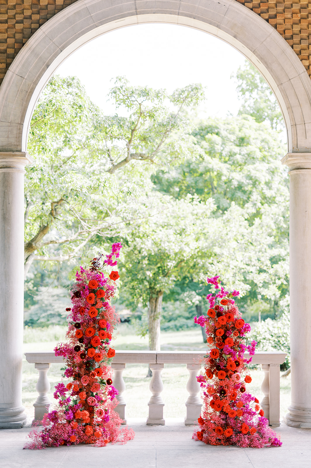 modern red and fuchsia floral wedding arch at the Columbus Park Refectory