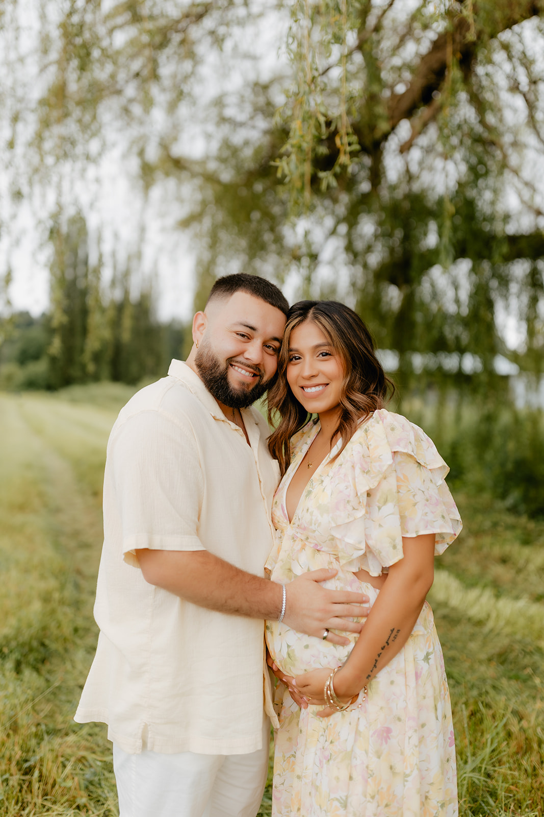 Photo of a young Latino couple posing for a maternity photoshoot in Woodinville, Washington.