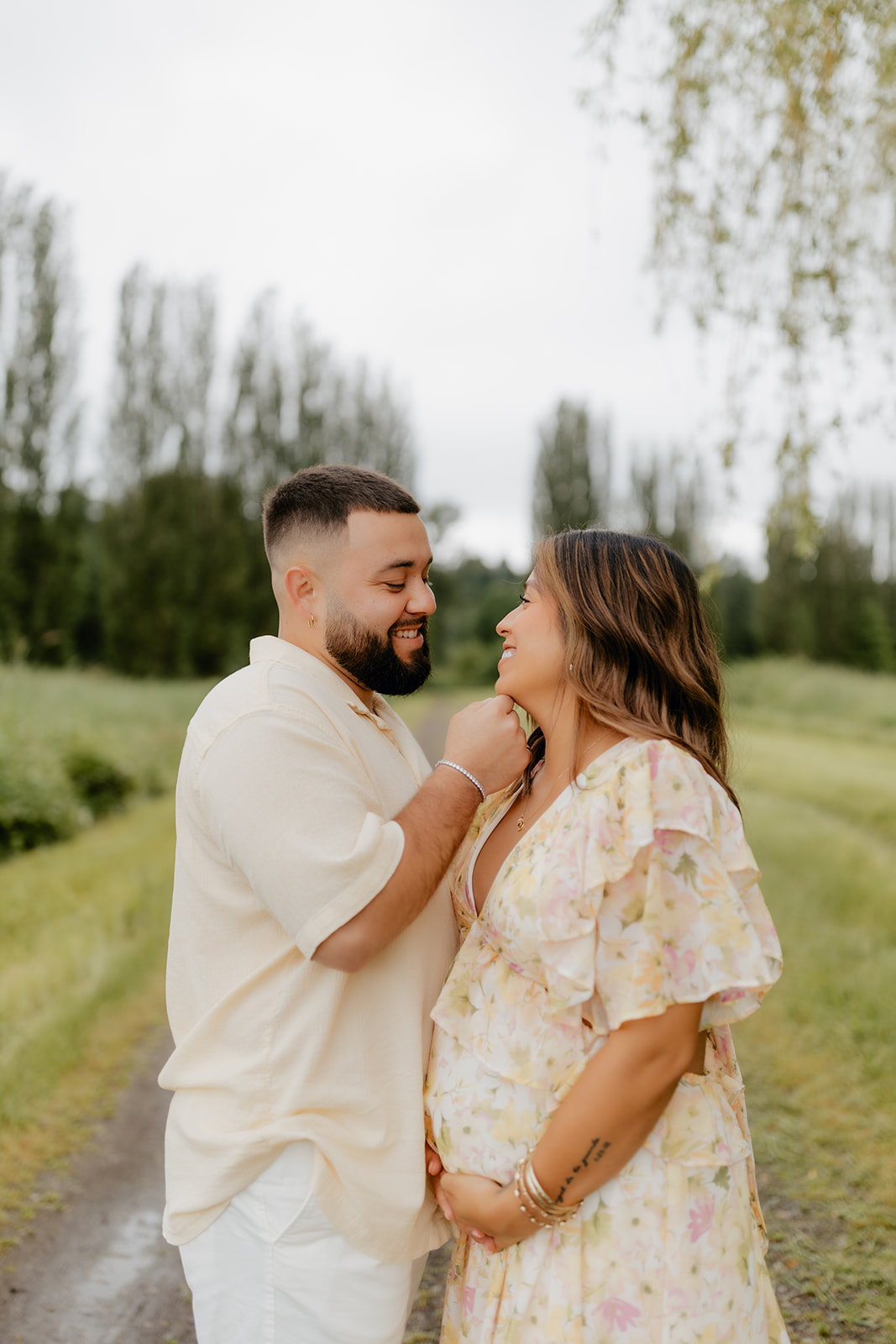 Photo of a young Latino couple posing for a maternity photoshoot in Woodinville, Washington.