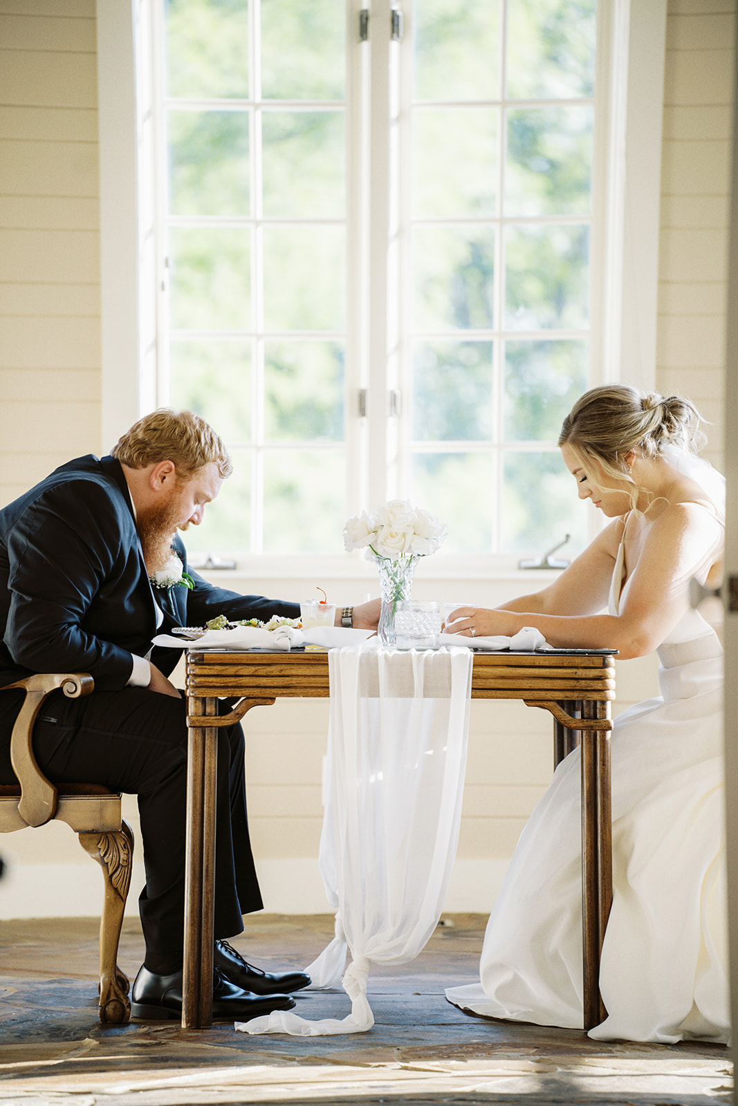 The bride and groom pray over their meal at Infinity Event Venue in Northeast Alabama