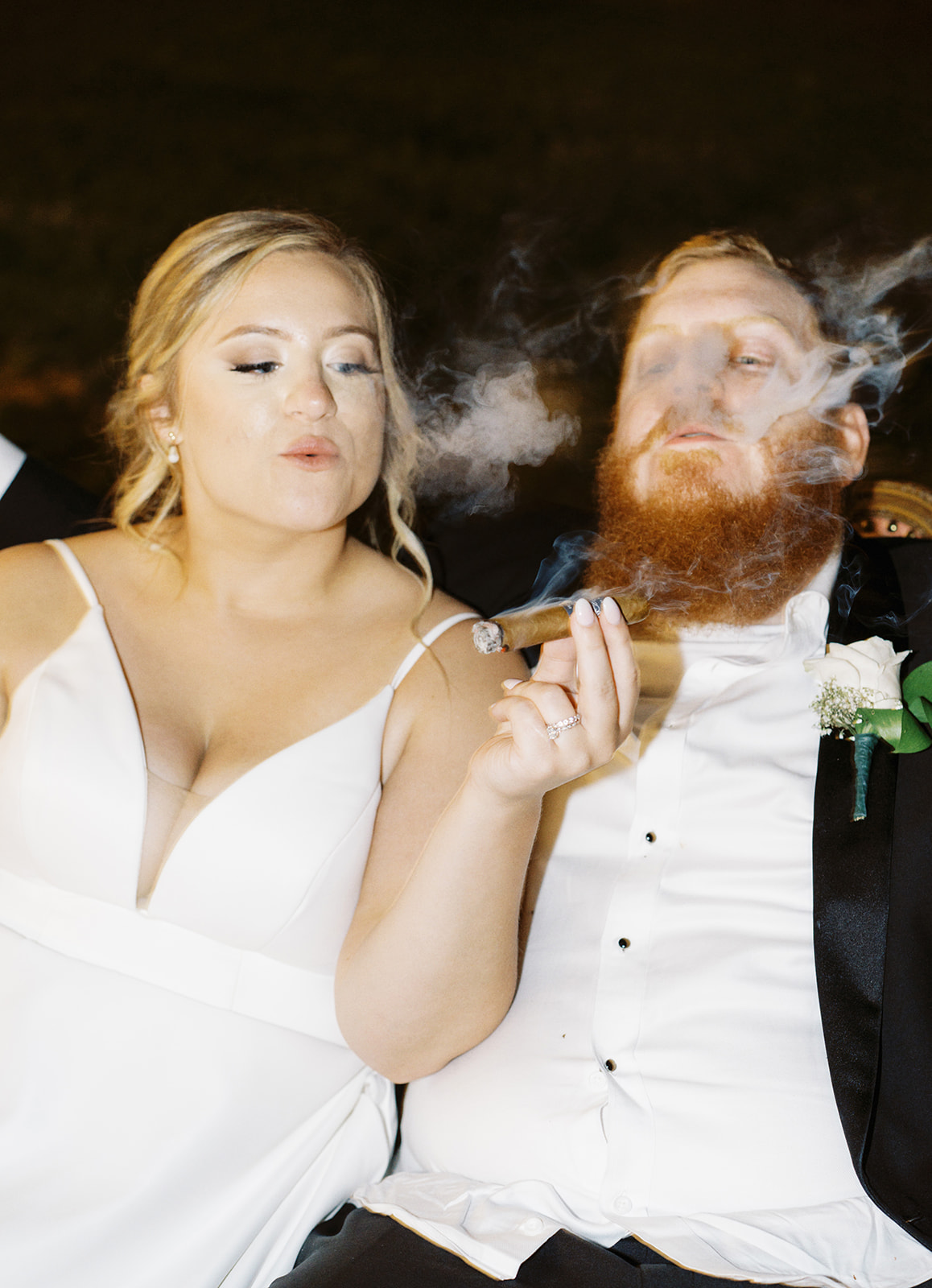 The bride and groom share a cigar during their wedding reception at Infinity Event Venue