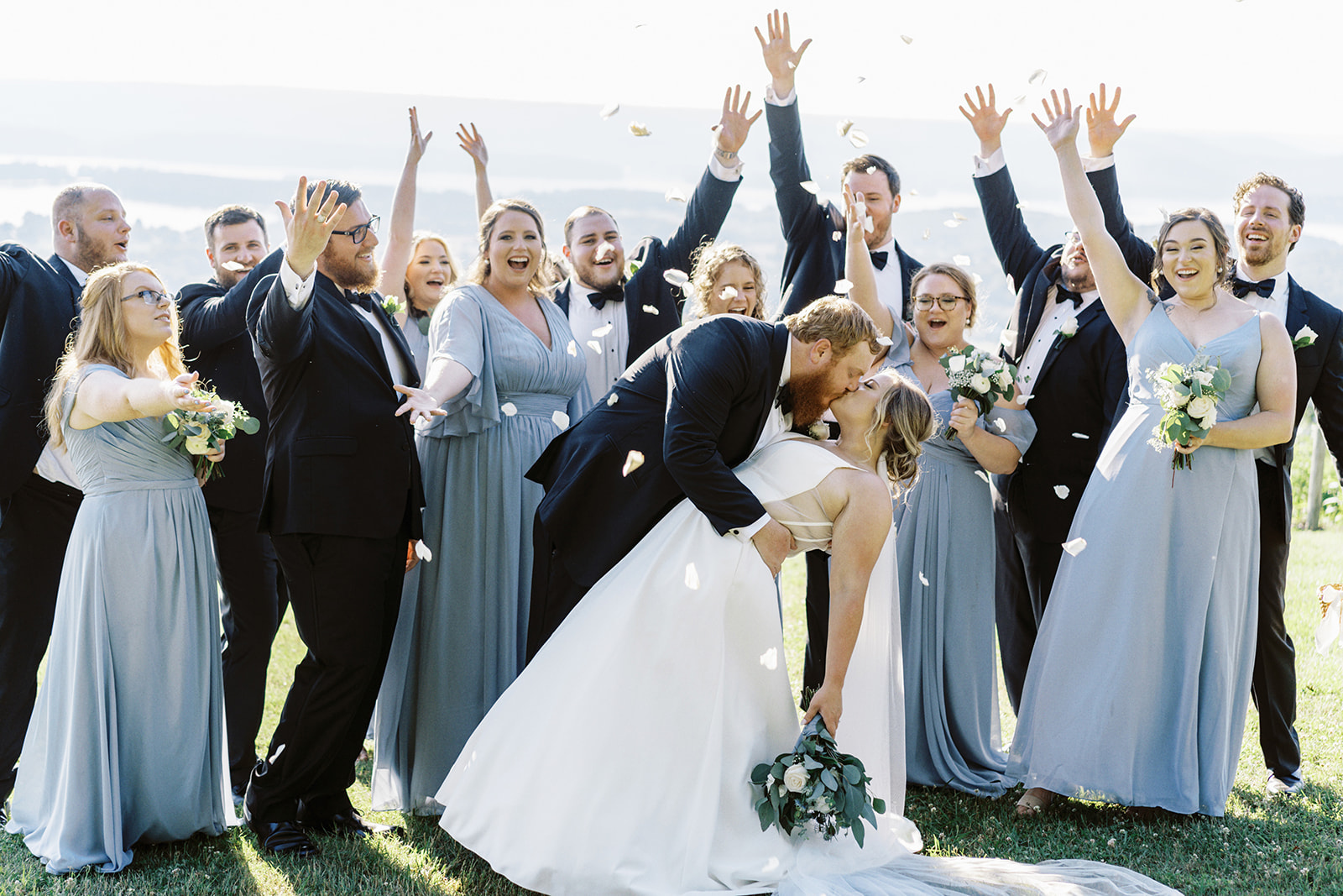 The wedding party throws petals over the bride and groom at Infinity Event Venue in Alabama
