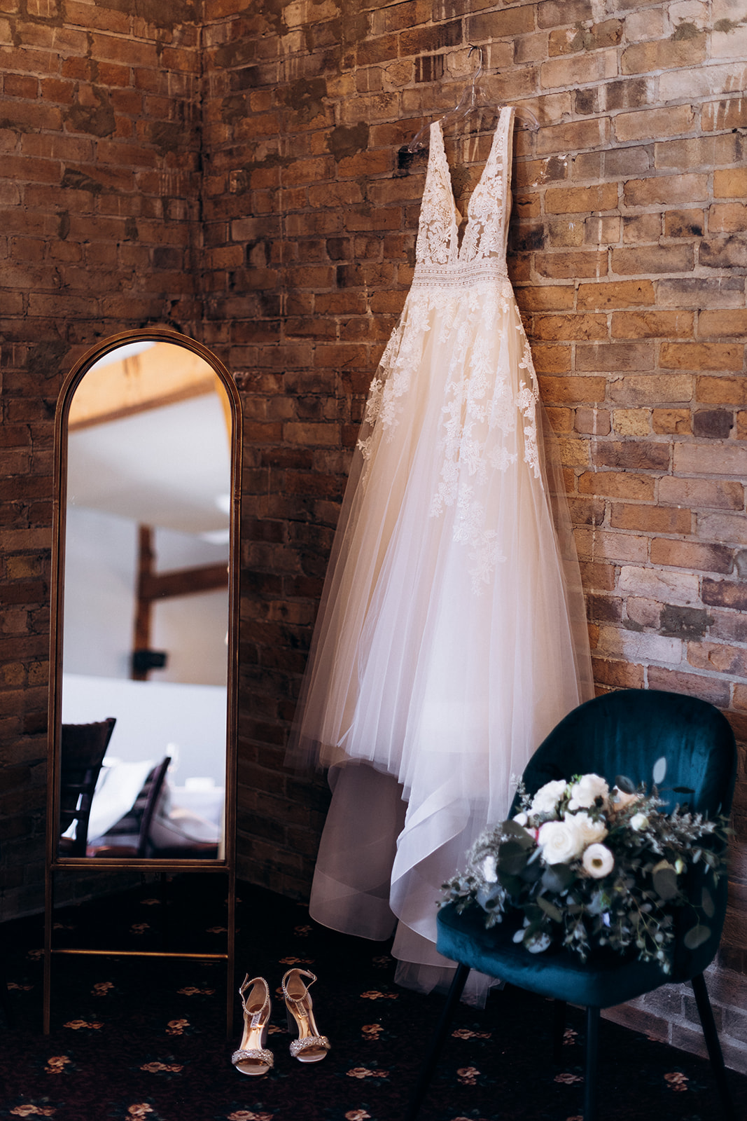 Wedding dress hanging on a brick wall at the Mill