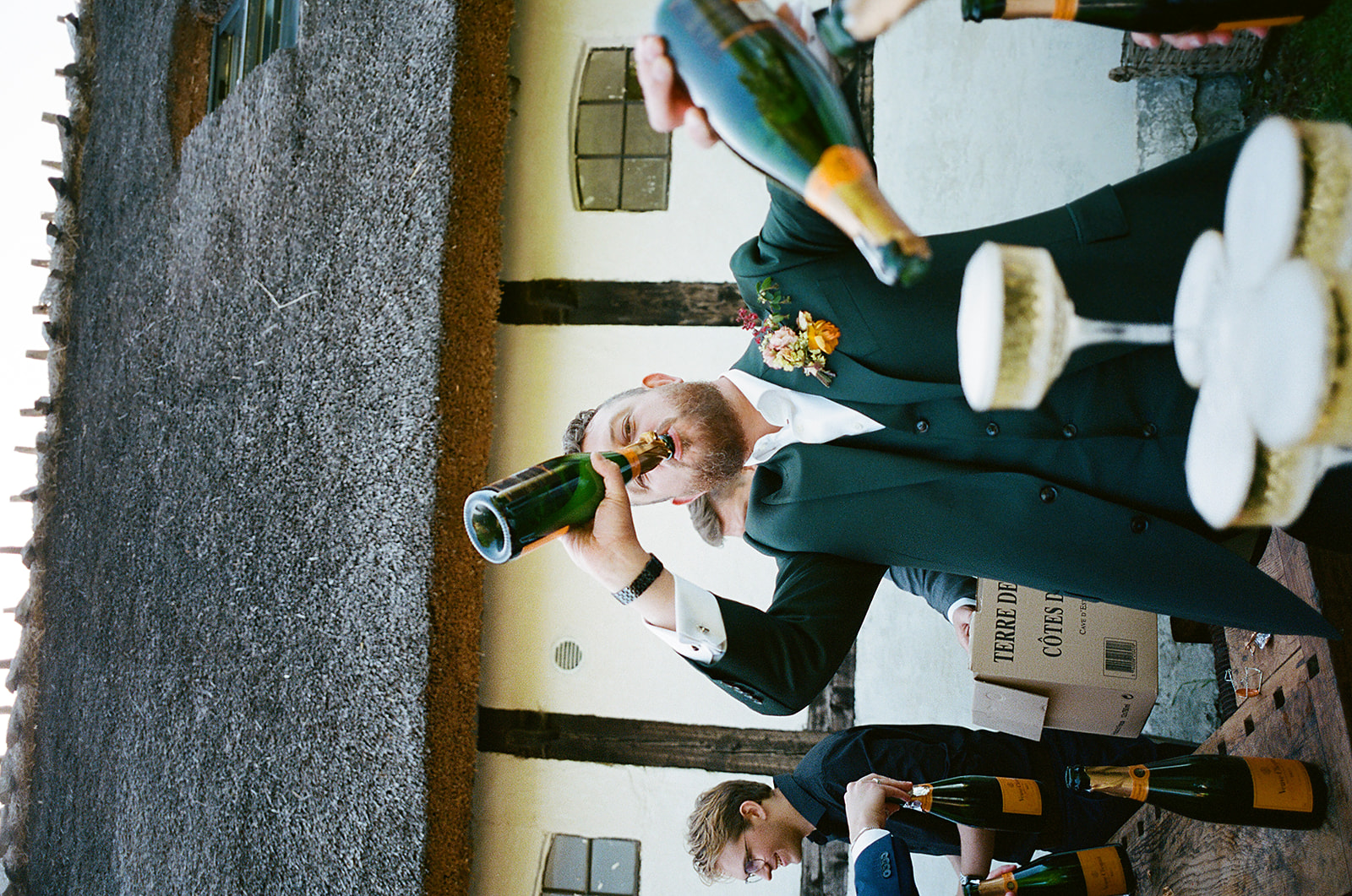 groom drinking from champagne bottle, shot on 35mm film