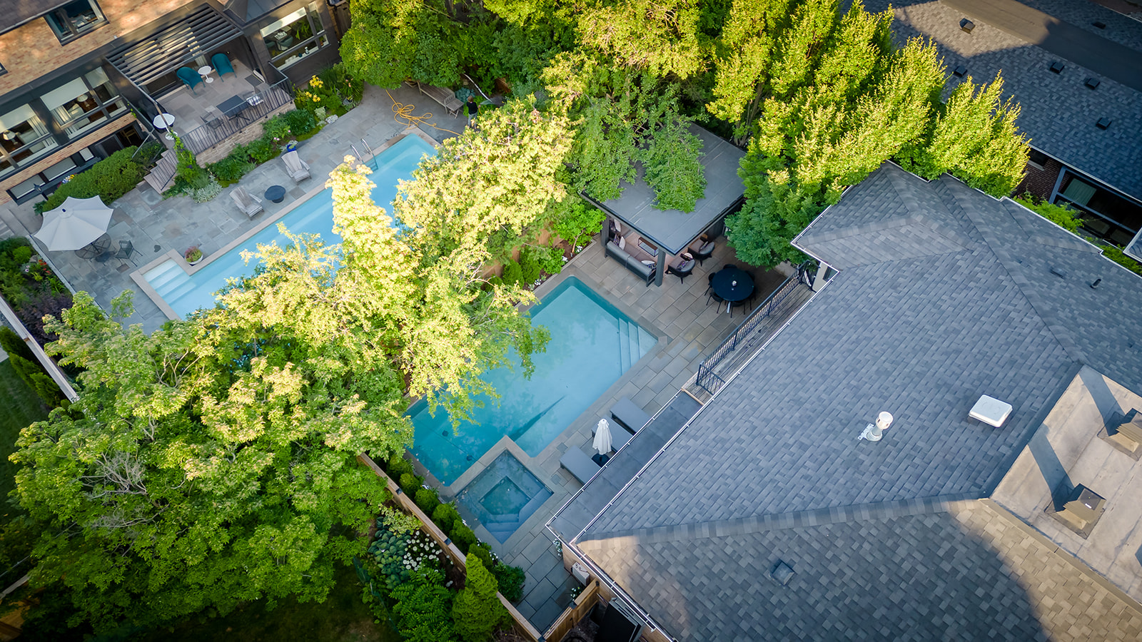 A drone-shot of the backyard with an inground pool.