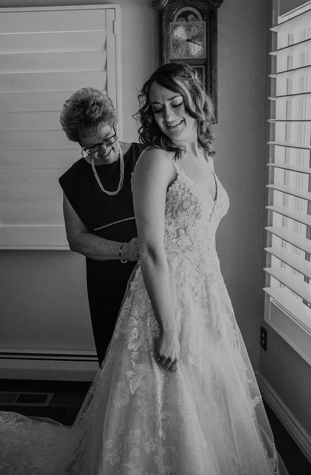 Bride's mom helps button up her wedding dress