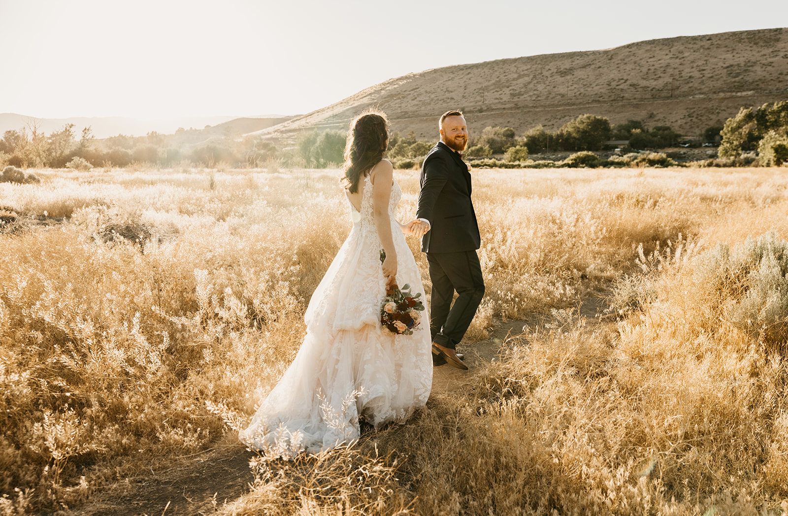 Bride and groom take couples photos in a golden field in Reno Nevada