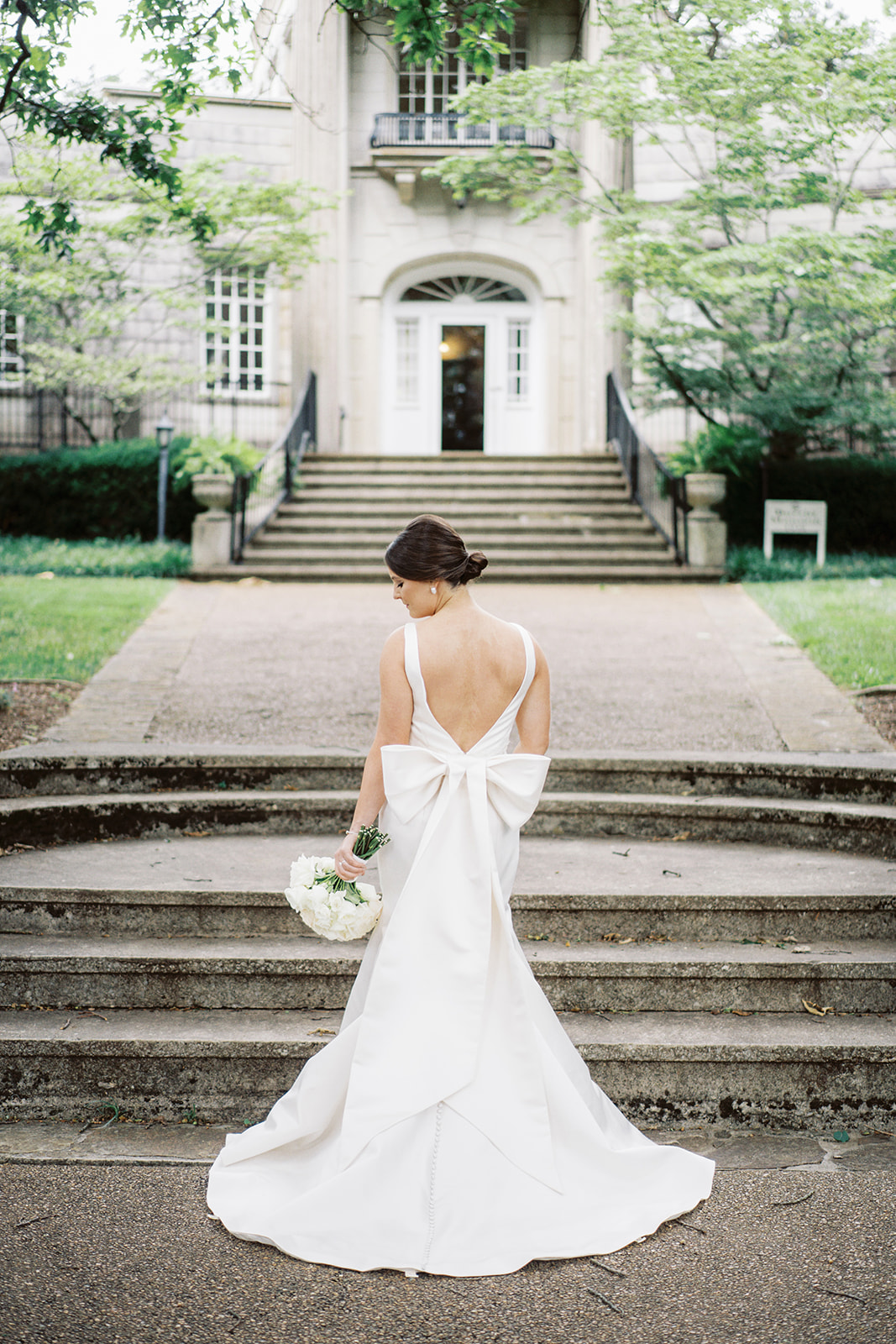 The bride stands in front of the mansion at Burritt on the Mountain in Huntsville, Alabama