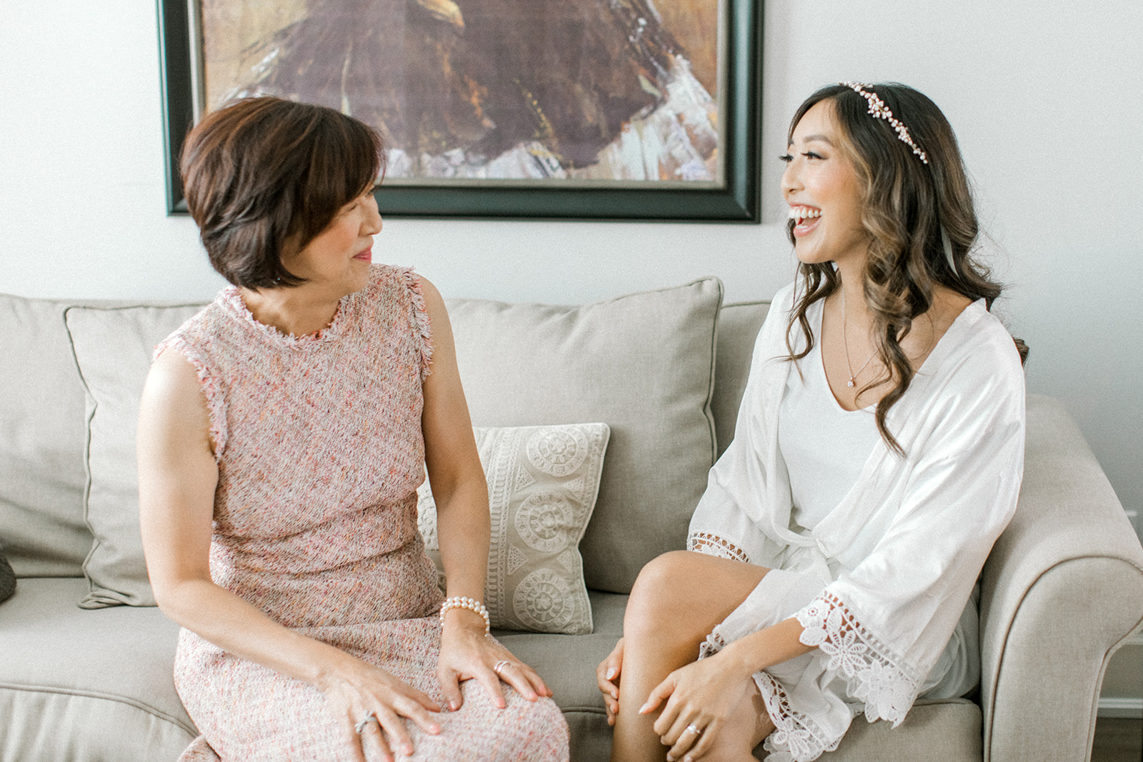 Mom and Daughter laugh together while getting ready on wedding day