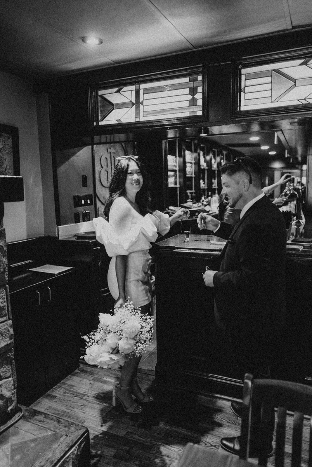 bride and groom doing shots in a bar