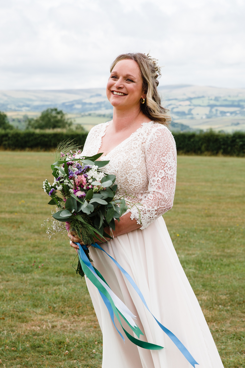 portrait of a bride holding flowers with views over Dartmoor in the background 