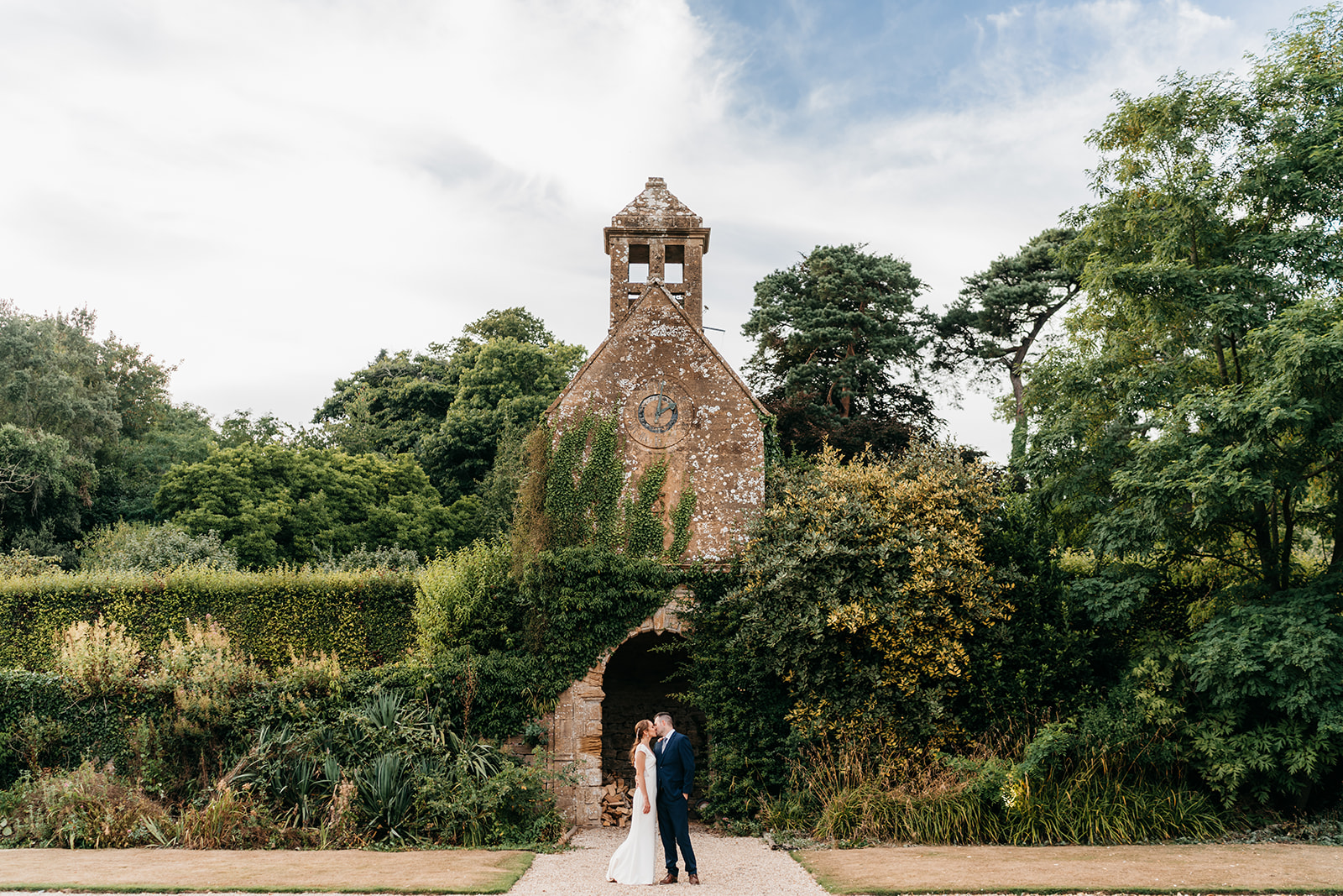 The bride and groom in front of the clock tower in Somerset