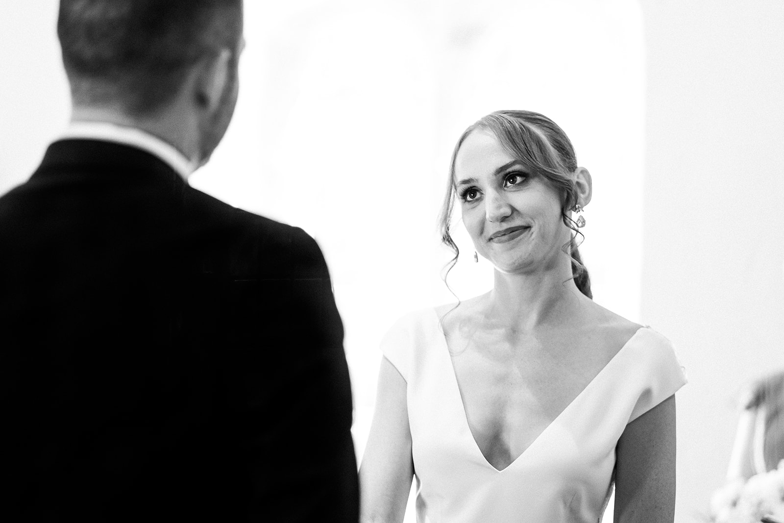 The bride looking at the groom during the ceremony. a black and white photograph
