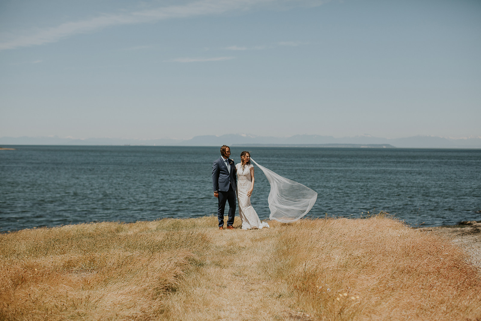 A bride and groom look at an ocean view on Saturna Island 