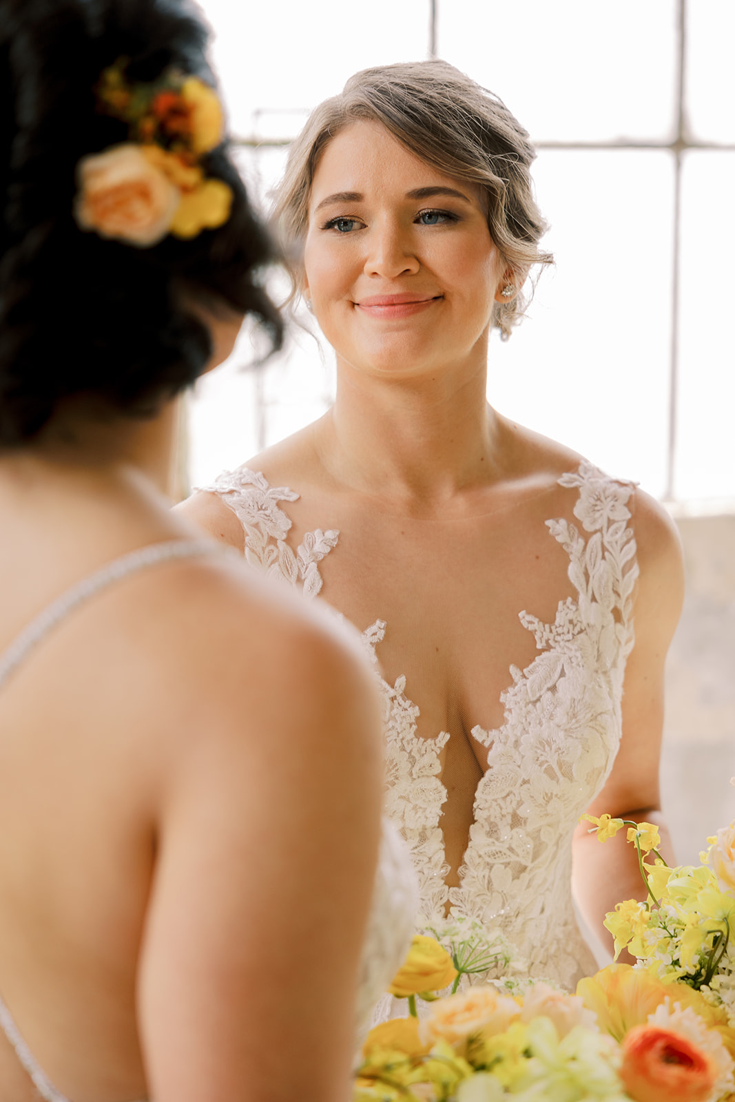 bride holding yellow and orange bouquet smiling